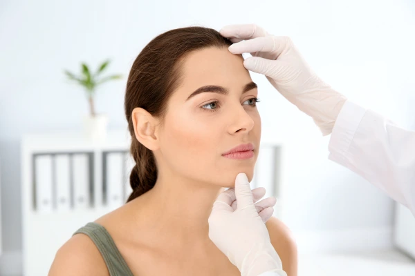 A dermatologist examining black pimple or dark spot to remove it effectively