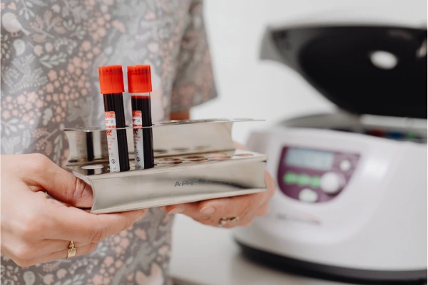 A therapist placing collected blood in a centrifuge