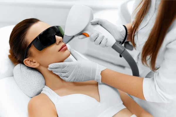 A therapist performing laser hair removal treatment