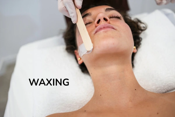 women taking waxing on her face
